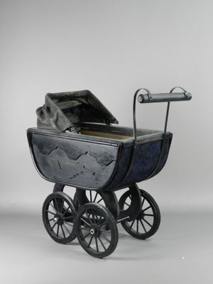 a toy stroller that is sitting on a white surface