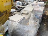 a lot of trash on the ground next to a yellow dumpster