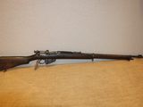 Un vieux fusil est posé sur une table près d'un mur.