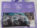 un sac de courses violet orné d'un motif tropical, posé sur une table blanche