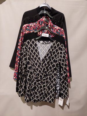 une chemise noire et blanche suspendue à un cintre près d'un mur blanc