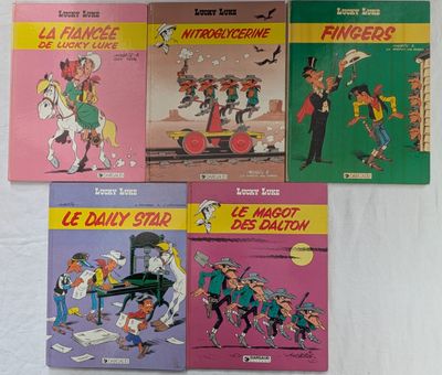 six livres pour enfants français posés sur un lit recouvert d'un drap blanc