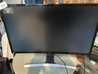 a computer monitor sitting on top of a table next to a keyboard
