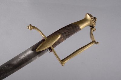 un gros plan d'une épée à la poignée dorée