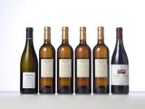 six bottles of wine are lined up on a table