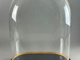 an image of a glass clochet with a black base and gold trim