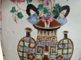 a vase with a painting on it sitting on a table