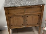 une armoire en bois avec un plan de travail en marbre dans une salle de bains