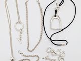 plusieurs colliers et bracelets différents posés sur un fond blanc