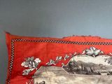 a red pillow with a picture of a horse and carriage on it