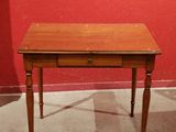 a small wooden table with a drawer on it