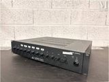 a black amplifier sitting on top of a table next to a brick wall