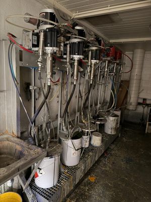Plusieurs seaux de lait sont alignés en rang dans une étable