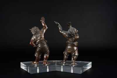 une paire de figurines en bronze représentant un garçon et une fille, posées sur un socle