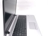 a silver laptop with a black keyboard on a white surface