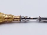 a silver and gold object with a spike on top of it