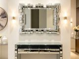 un grand miroir accroché au mur au-dessus d'une table dans une pièce