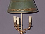 une lampe posée sur une table, avec un abat-jour vert