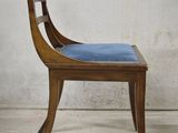 a wooden chair with a blue cushion on top of it