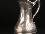 un pichet ancien en argent sur fond noir, avec un fond noir