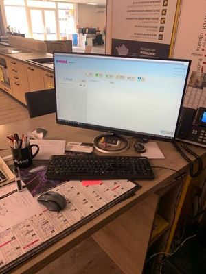 un bureau sur lequel se trouvent un ordinateur, un clavier, une souris et un téléphone