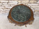 a marble top on a wooden table in front of a stone wall