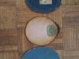 three plates that are sitting on a wooden floor