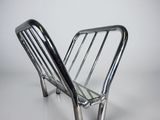 une image représentant une chaise en métal posée sur une surface blanche