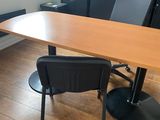 a wooden table with black chairs in a room