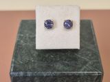 une paire de boucles d'oreilles en saphir bleu posées sur un bloc de marbre