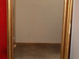 a mirror that is sitting on the floor in front of a red wall