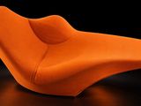 un fauteuil orange posé sur une surface noire