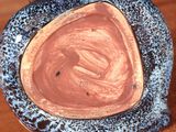 a close up of a blue and black vase on a wooden table
