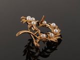 a gold and pearl broochle with leaves and pearls