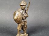 bronze figurine of a soldier holding a sword and shield