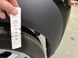 a hand that is holding a ruler near a tire