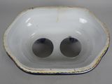 a white bowl with two holes in it on a table