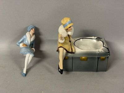 two figurines of a woman sitting on a bench