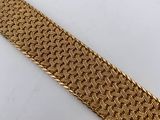 a gold bracelet with a braid design on it