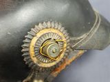 a hand holding a black hat with a gold star on it