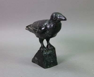statue of a bird on a rock on a gray background