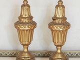 deux vases dorés posés sur une table en marbre