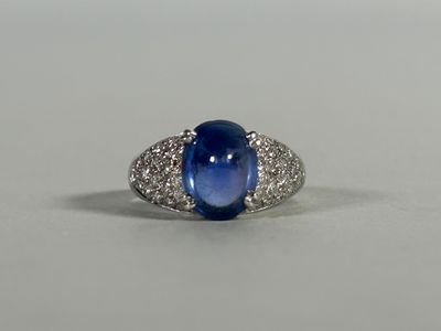 an oval blue sapphire and diamond ring on a white surface