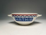 a white bowl with a blue and red design on it