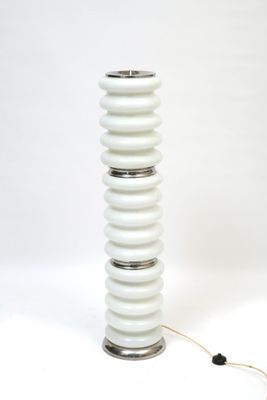 a white table lamp that is on a white surface
