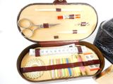 a leather case with a pair of scissors and other items in it