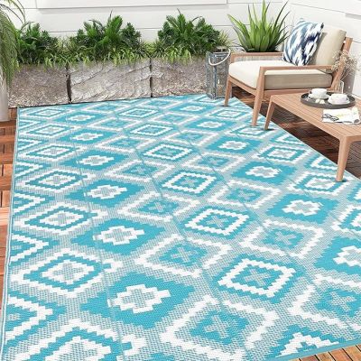 un tapis d'extérieur bleu et blanc posé sur une terrasse en bois