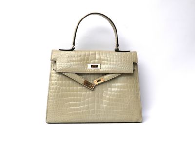 a white purse sitting on top of a table next to a white wall
