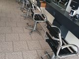 une rangée de chaises dans un salon de coiffure, où l'on attend les clients