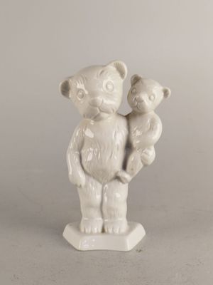 une statue blanche représentant un ours tenant un ourson dans ses bras